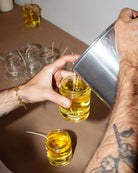 candle wax being poured into a glass jar