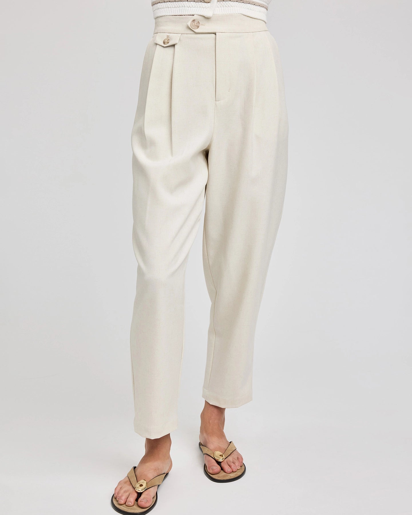 Beige pants in cream with a pleat and brass button detailing