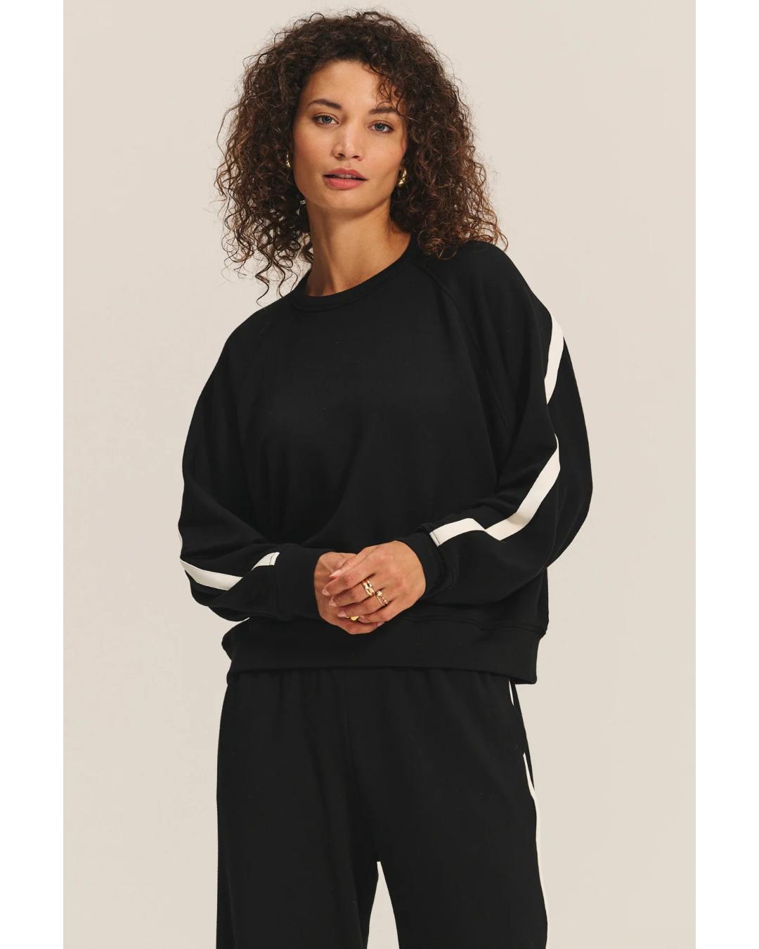 black crewneck sweatshirt with a white stripe across the back and arms