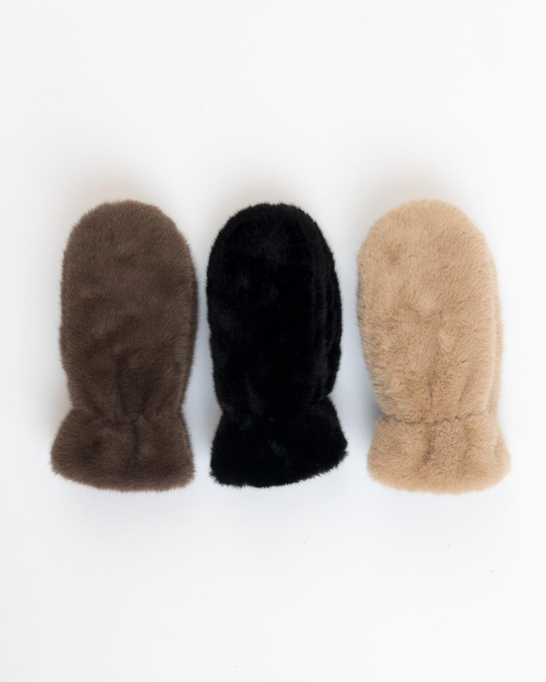 three fuzzy mittens in brown, black and camel