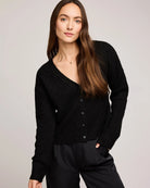 a woman wears a pointelle v neck button down cardigan in black by gentle fawn