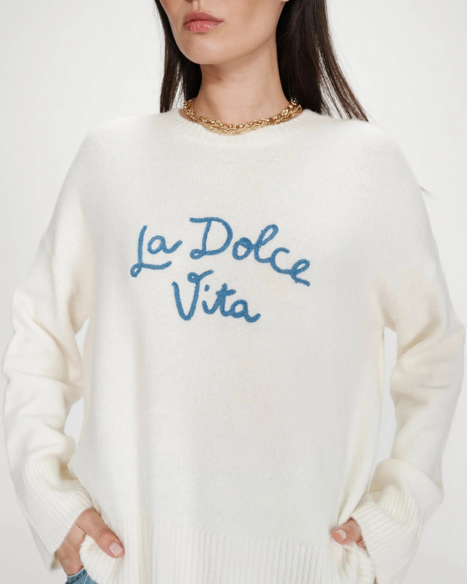 white oversized knit sweater with the text la dolce vita in blue