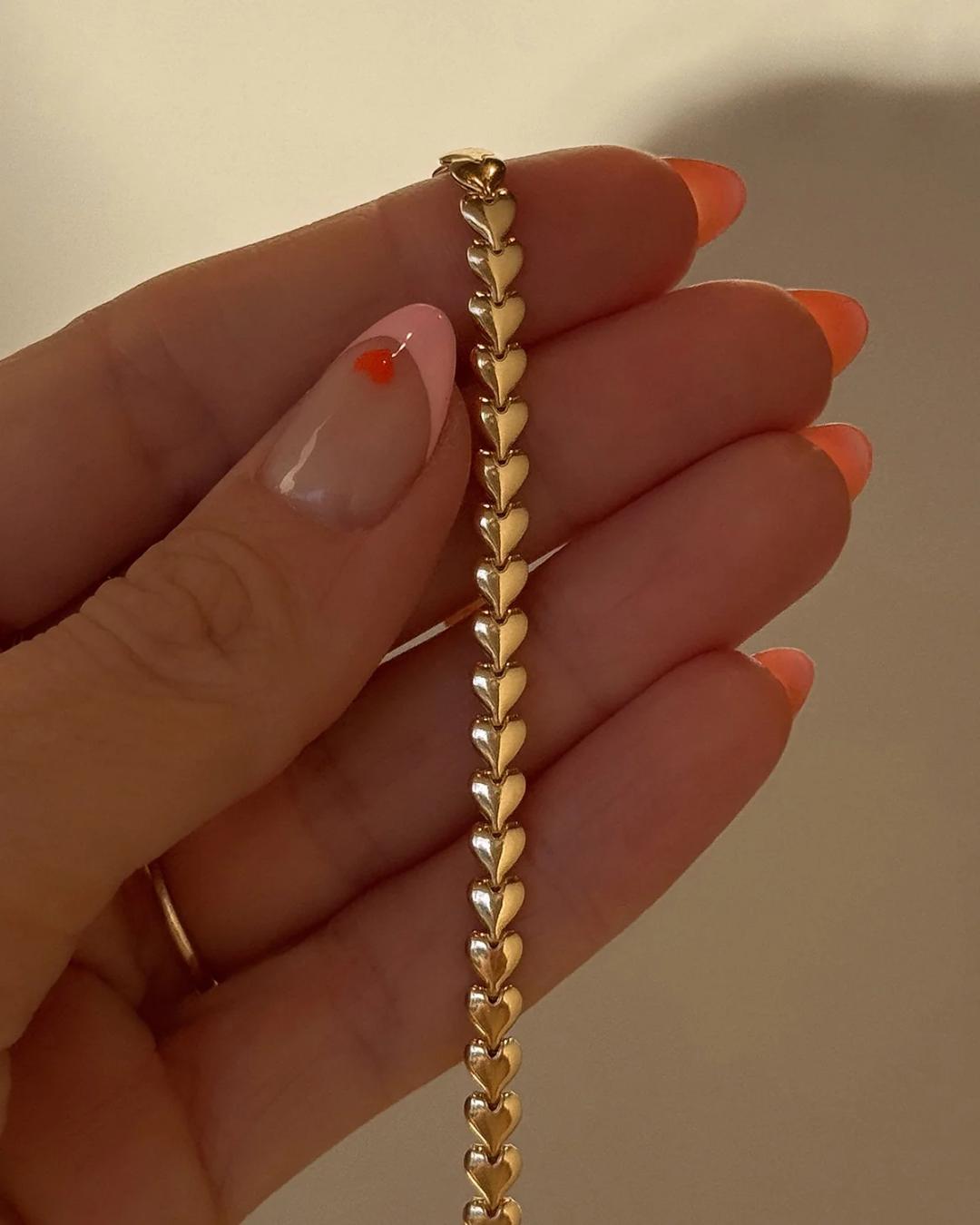 gold herring bone necklace in the shape of hearts