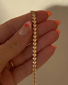 gold herring bone necklace in the shape of hearts