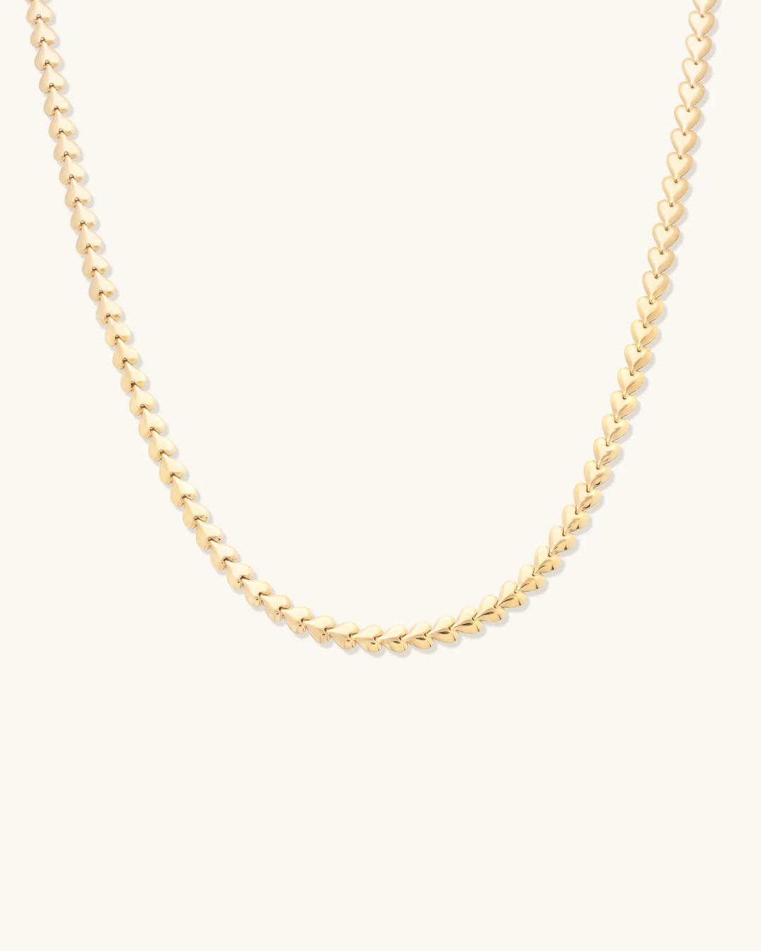 gold herring bone necklace in the shape of hearts