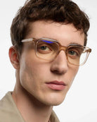 a man wears a pair of clear pink eyeglasses for blue light by Barner