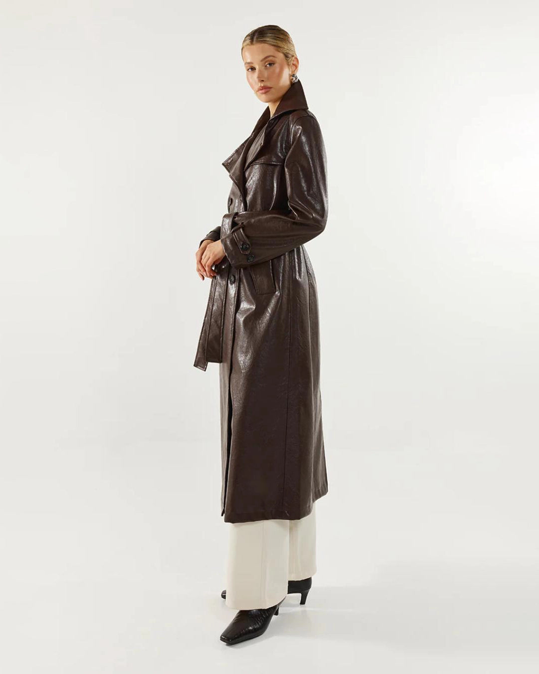 Woman wearing a long brown leather coat