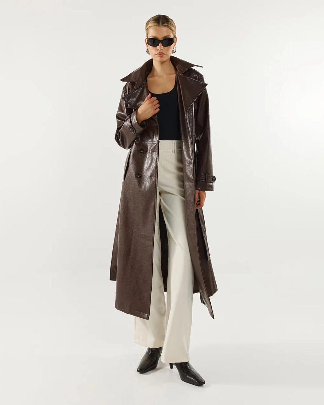 Woman wearing a long brown leather coat