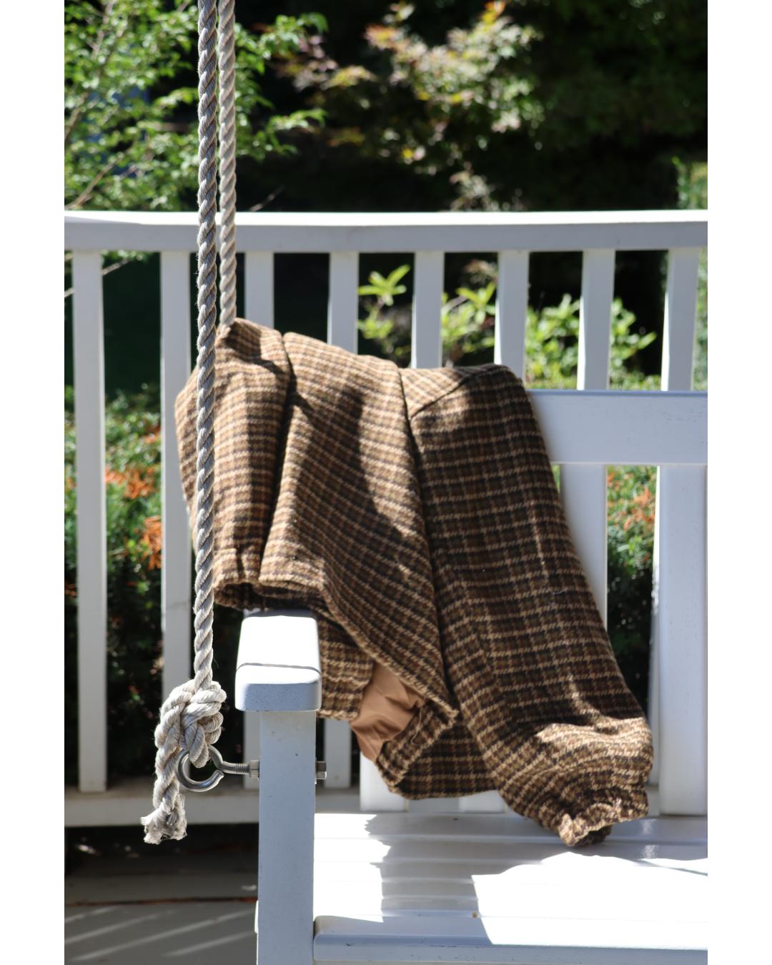 a plaid jacket with jeans and sunglasses