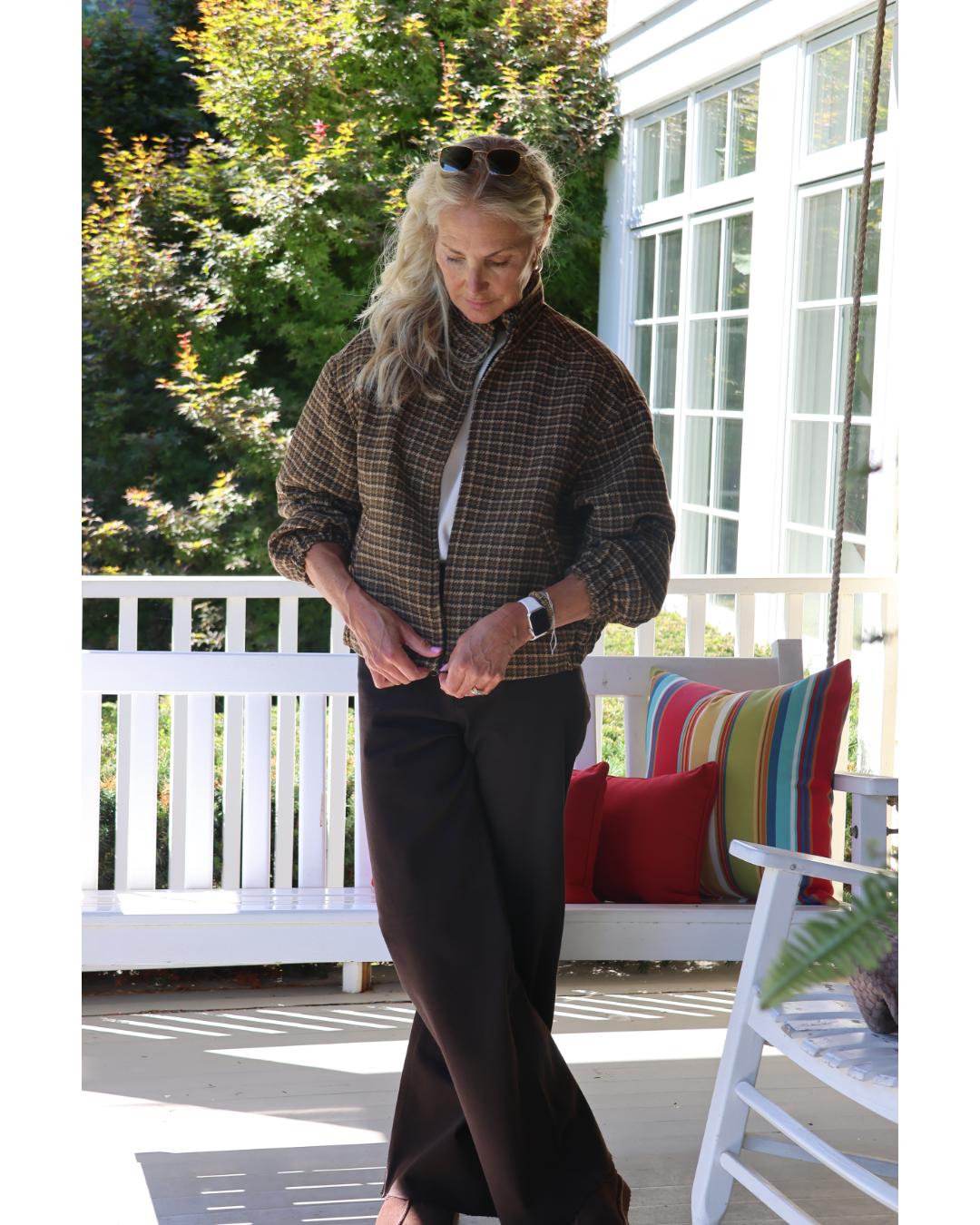 woman wearing a plaid jacket with jeans and sunglasses