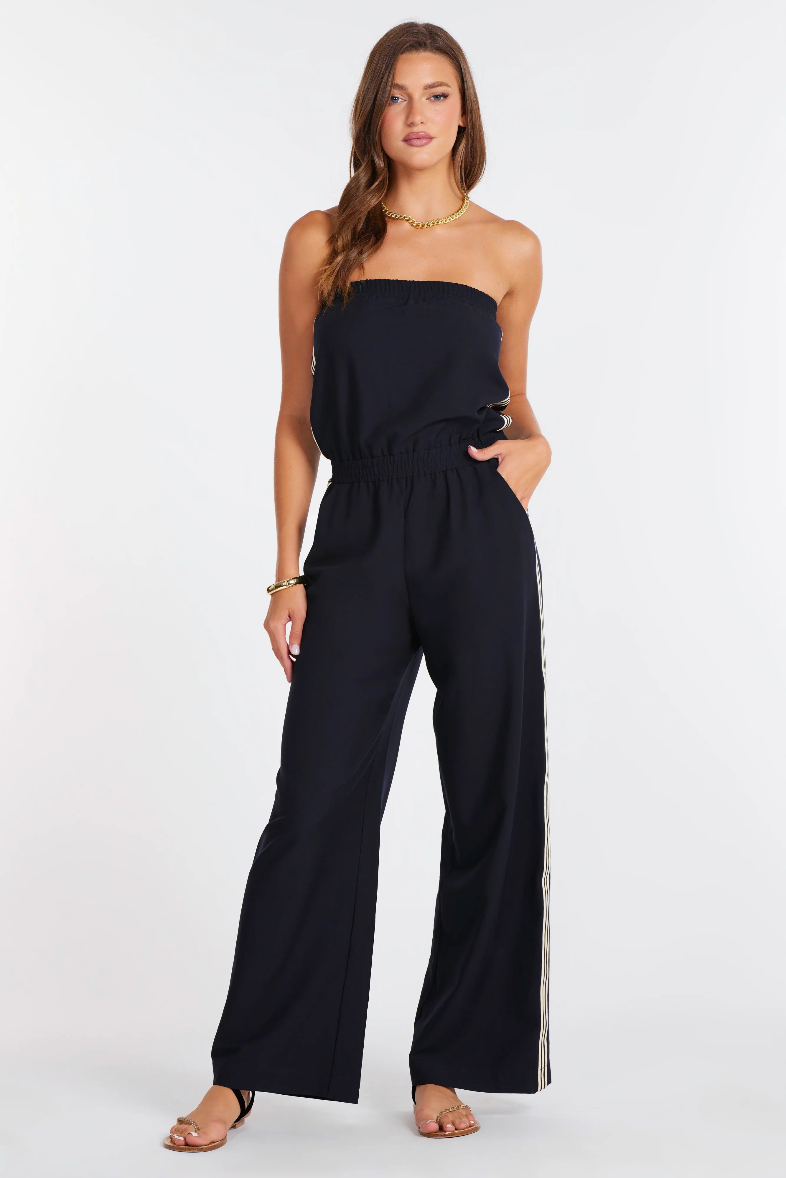 strapless navy jumpsuit with a white stripes down the side