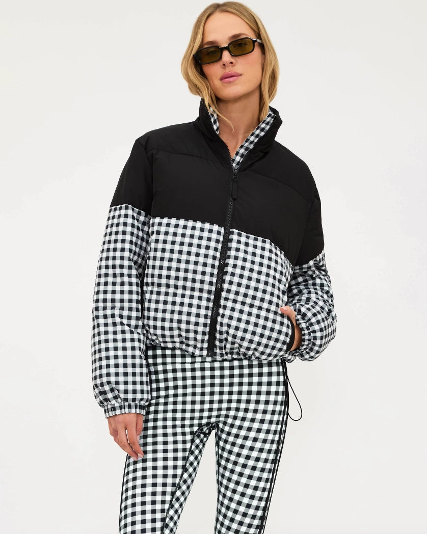 Woman wearing a black and white checkered puffer jacket in black gingham