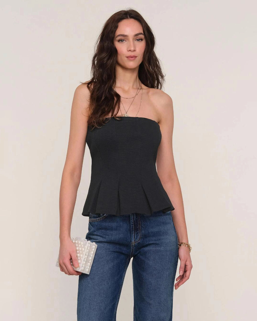 Woman wearing a black strapless peplum top