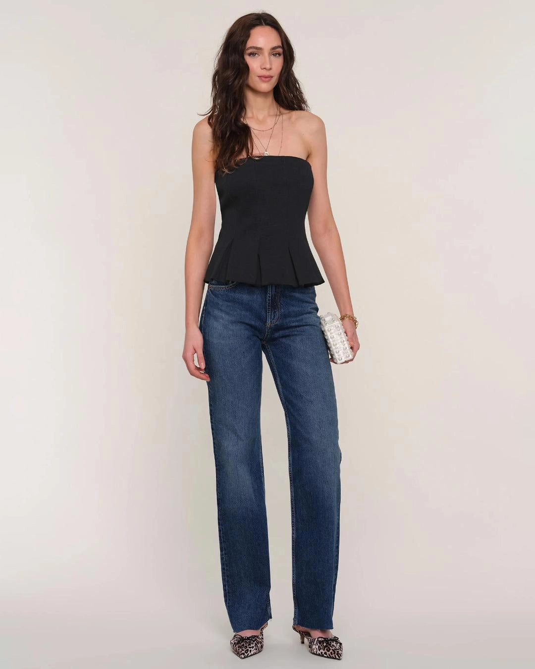 Woman wearing a black strapless peplum top