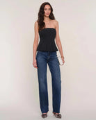 Woman wearing a black strapless peplum top