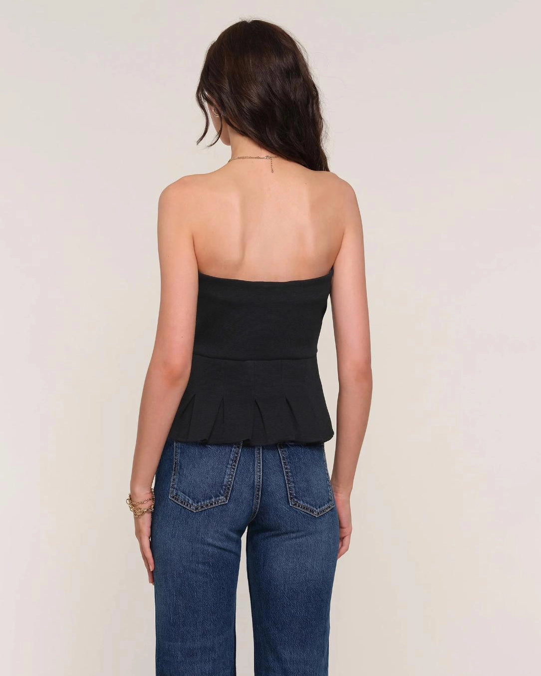 Woman wearing a black strapless peplum top