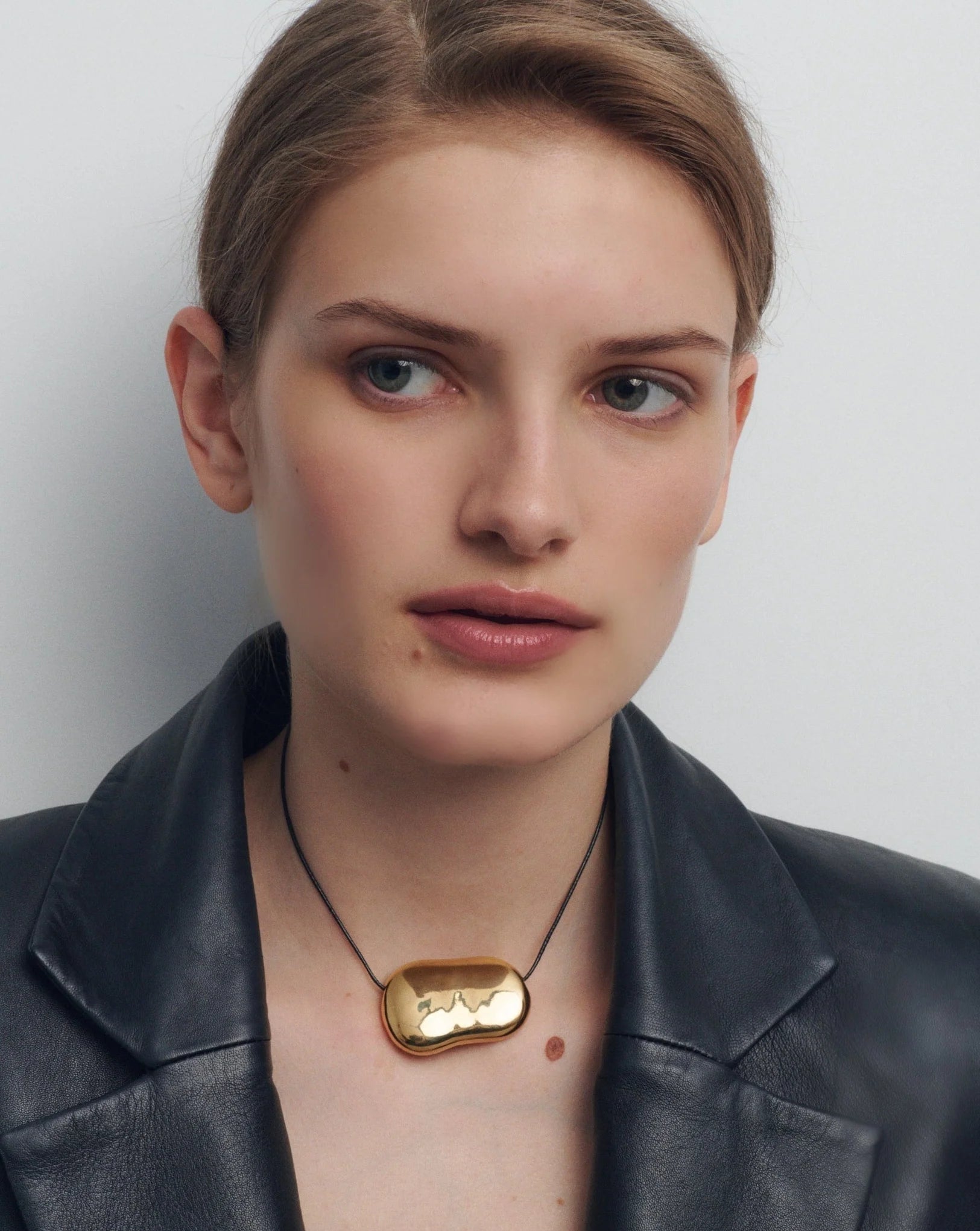 black string necklace with statement gold pendent