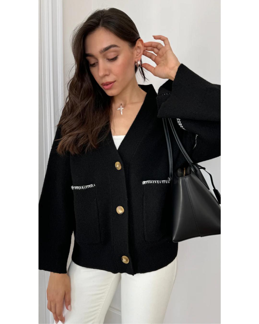 black cardigan with white stitching on the pockets