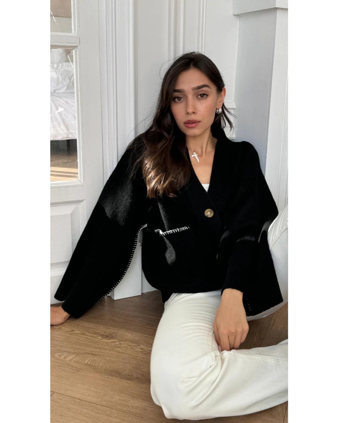 black cardigan with white stitching on the pockets