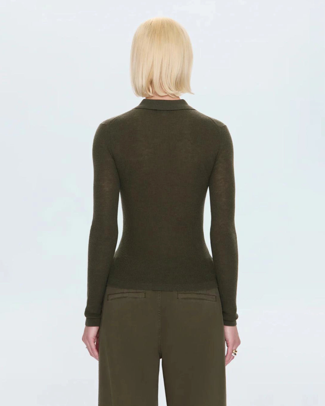 woman wearing a ribbed long sleeve top with a collar and buttons down the front in green