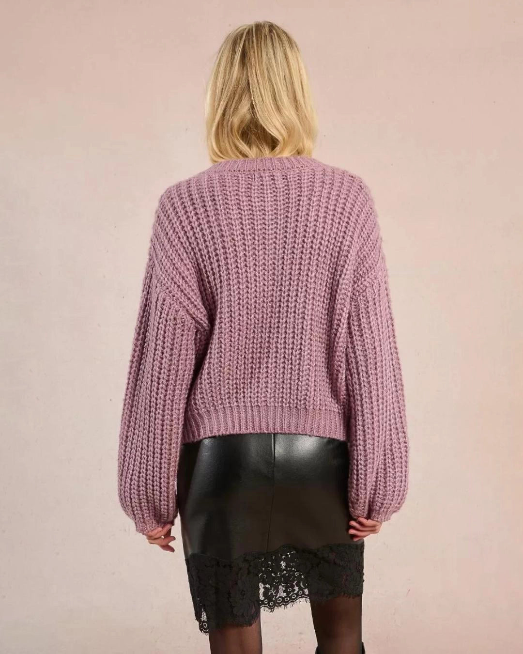 woman wearing a loose knit cardigan with large buttons and bubble sleeves in mauve purple