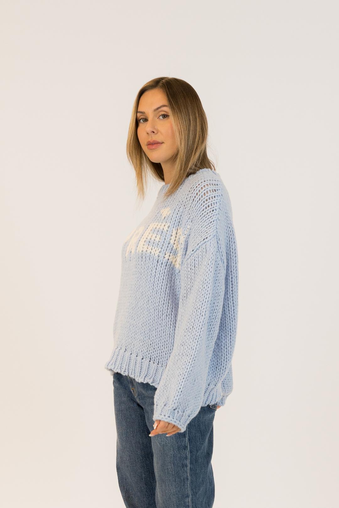blue knit sweater with apres written on the front