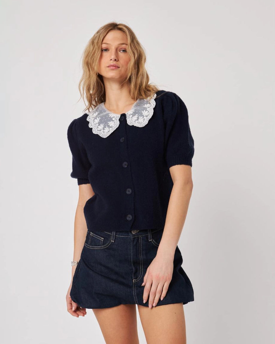 woman wearing navy blue button down cardigan sweater with lace peter pan collar on it in white