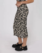 woman wearing a midi skirt in beige with black floral pattern all over by sage the label