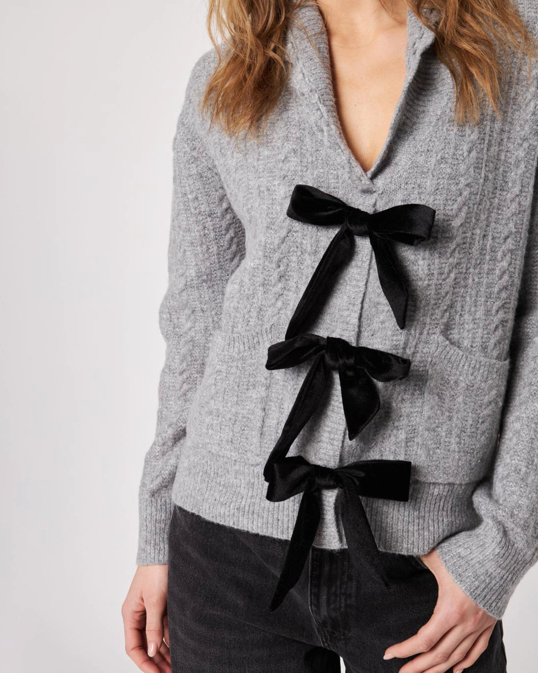 grey cardigan with three black bows down the front