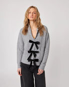 grey cardigan with three black bows down the front