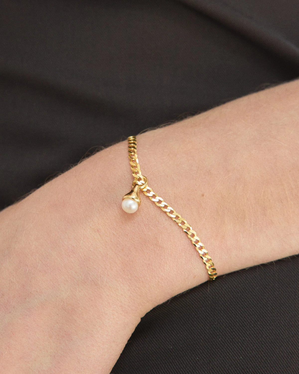 gold bracelet with a pearl charm