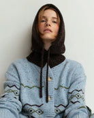 Person wearing a brown knitted hood hat