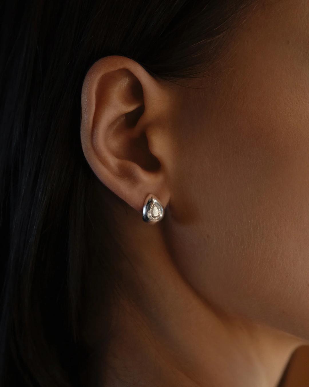 silver tear drop earring with diamond in the middle