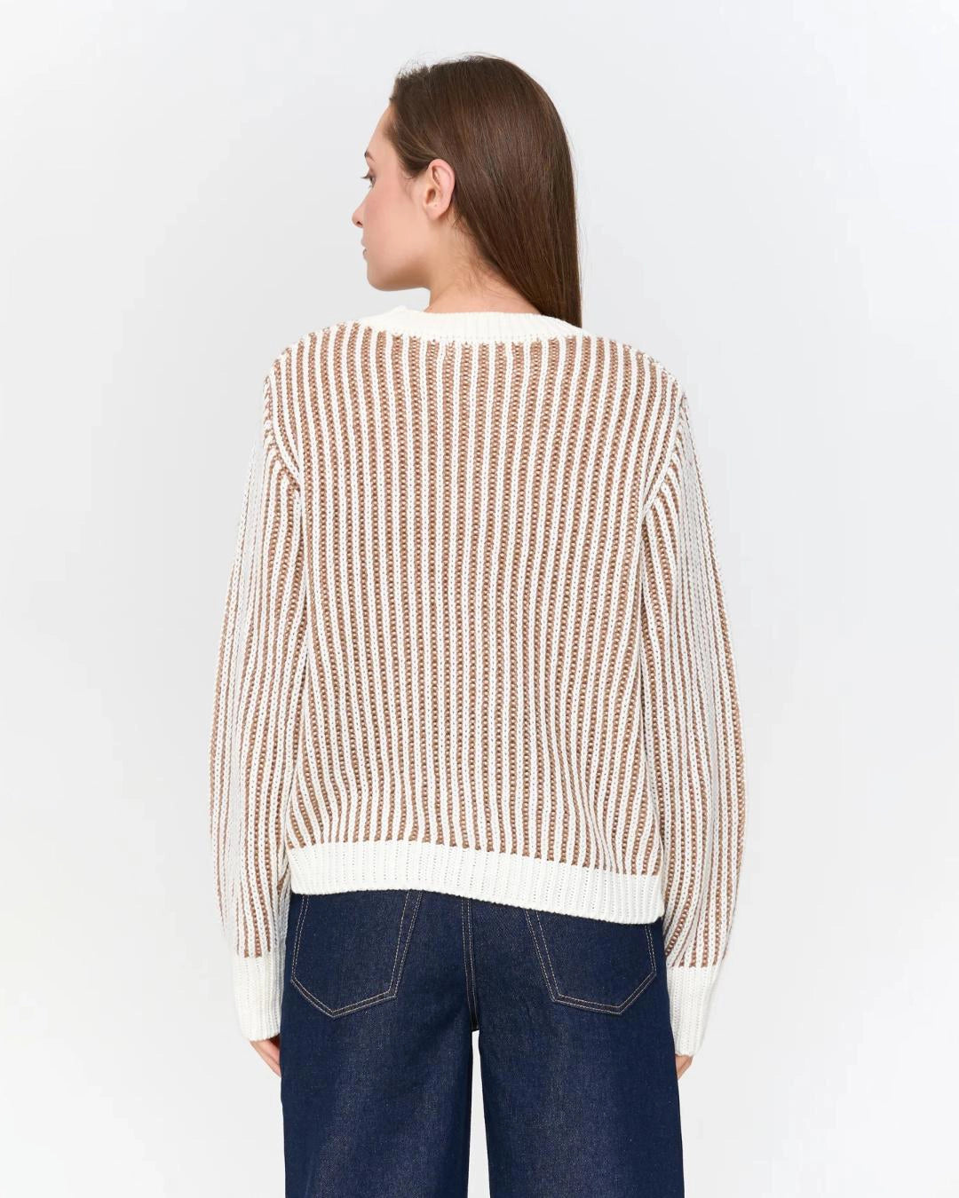Woman wearing a striped knit beige and white sweater
