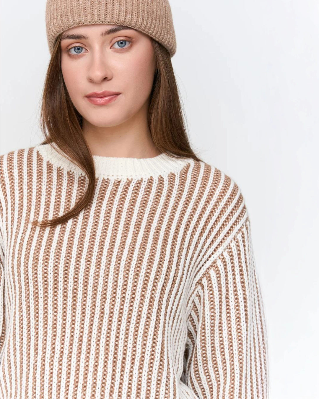 Woman wearing a striped knit beige and white sweater