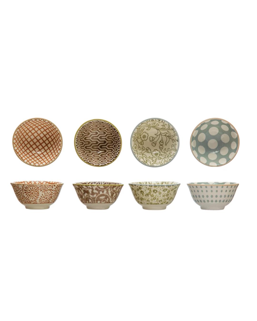 Set of eight ceramic bowls with various patterns on a white background