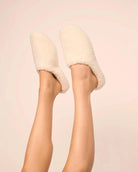 White fluffy sherpa slippers on feet