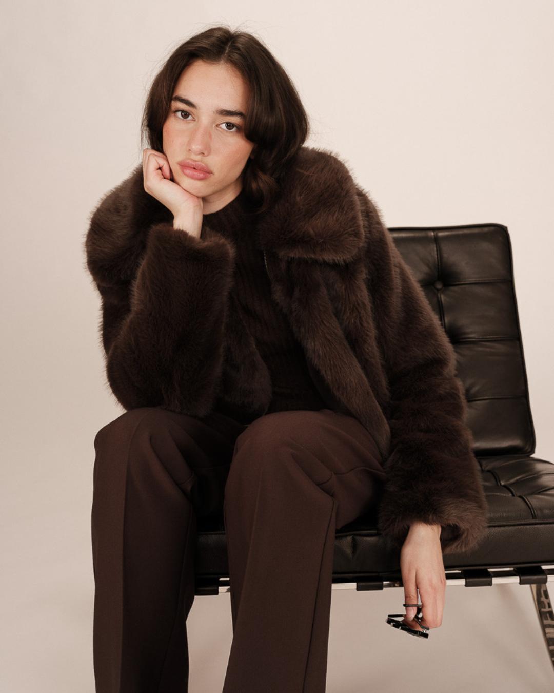 Woman wearing a brown faux fur coat with large lapels