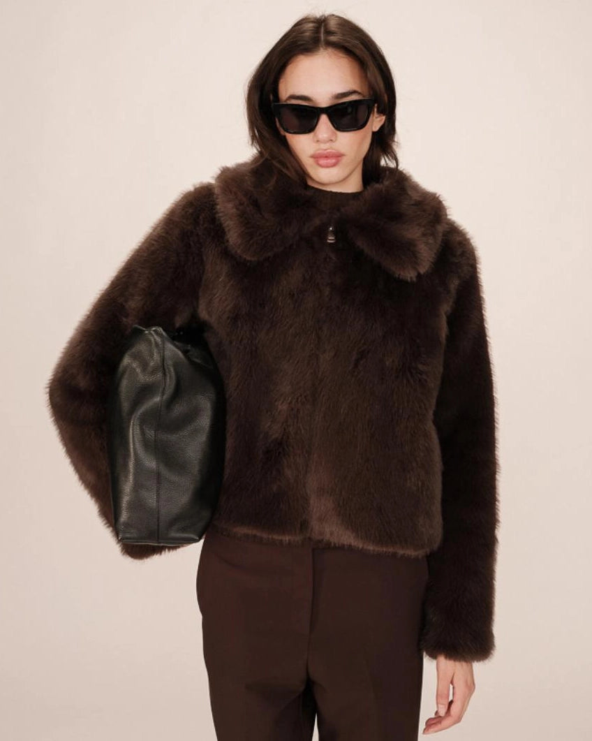 Woman wearing a brown faux fur coat with large lapels