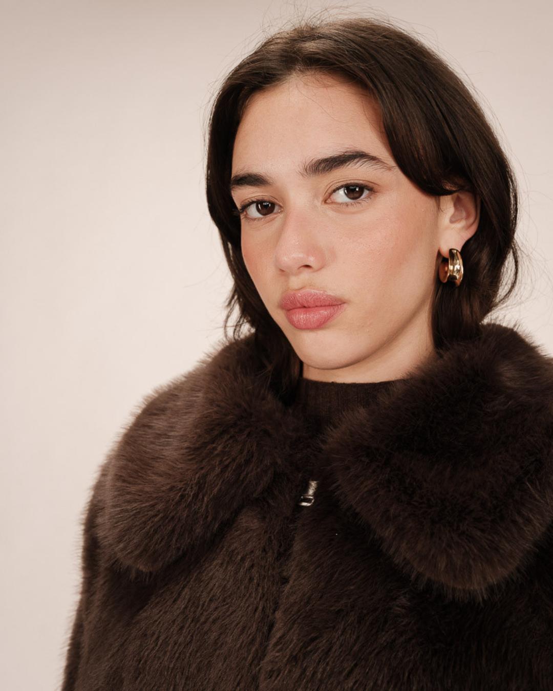 Woman wearing a brown faux fur coat with large lapels
