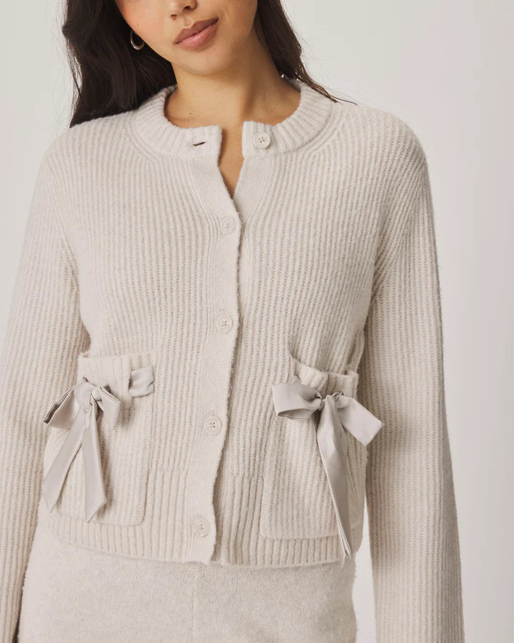 cream cardigan with satin bows on the pockets