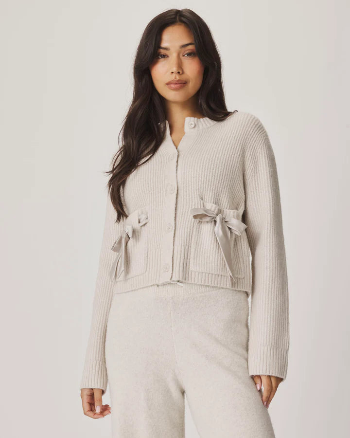 cream cardigan with satin bows on the pockets