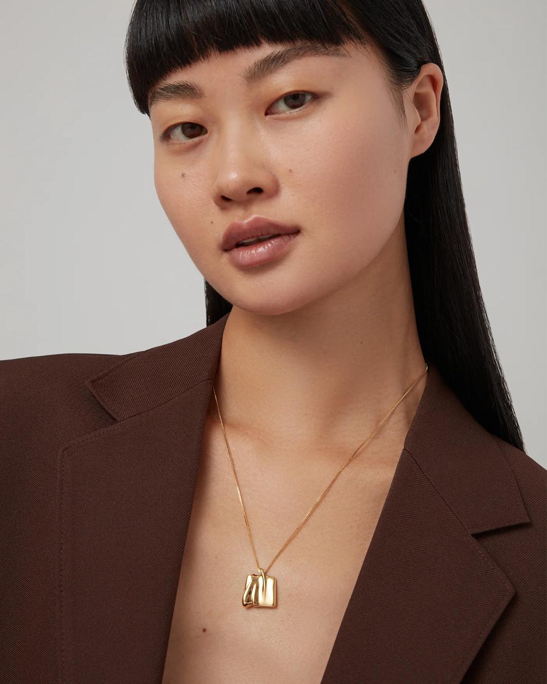 gold necklace with a square gold pendant