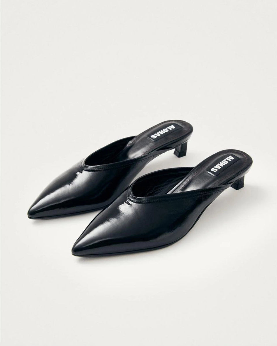 black leather mules with a pointed toe with 'Alohas' logo on them