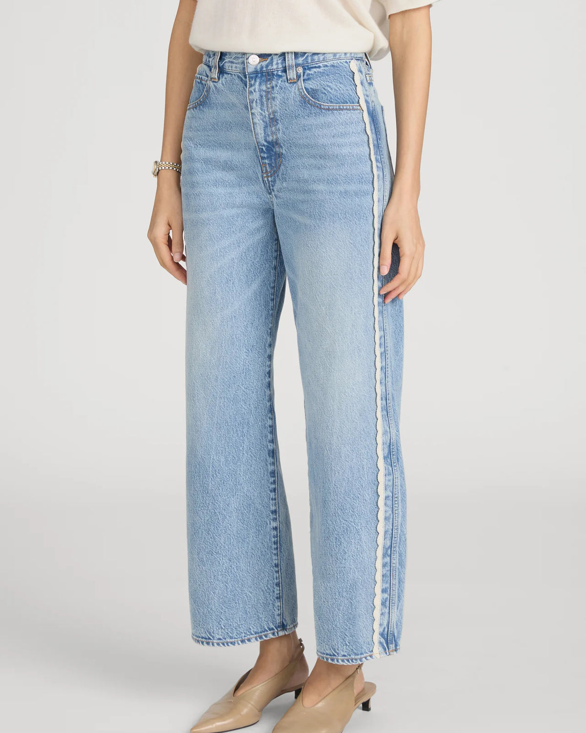cropped light wash denim pant with a cream crochet detail on the sides