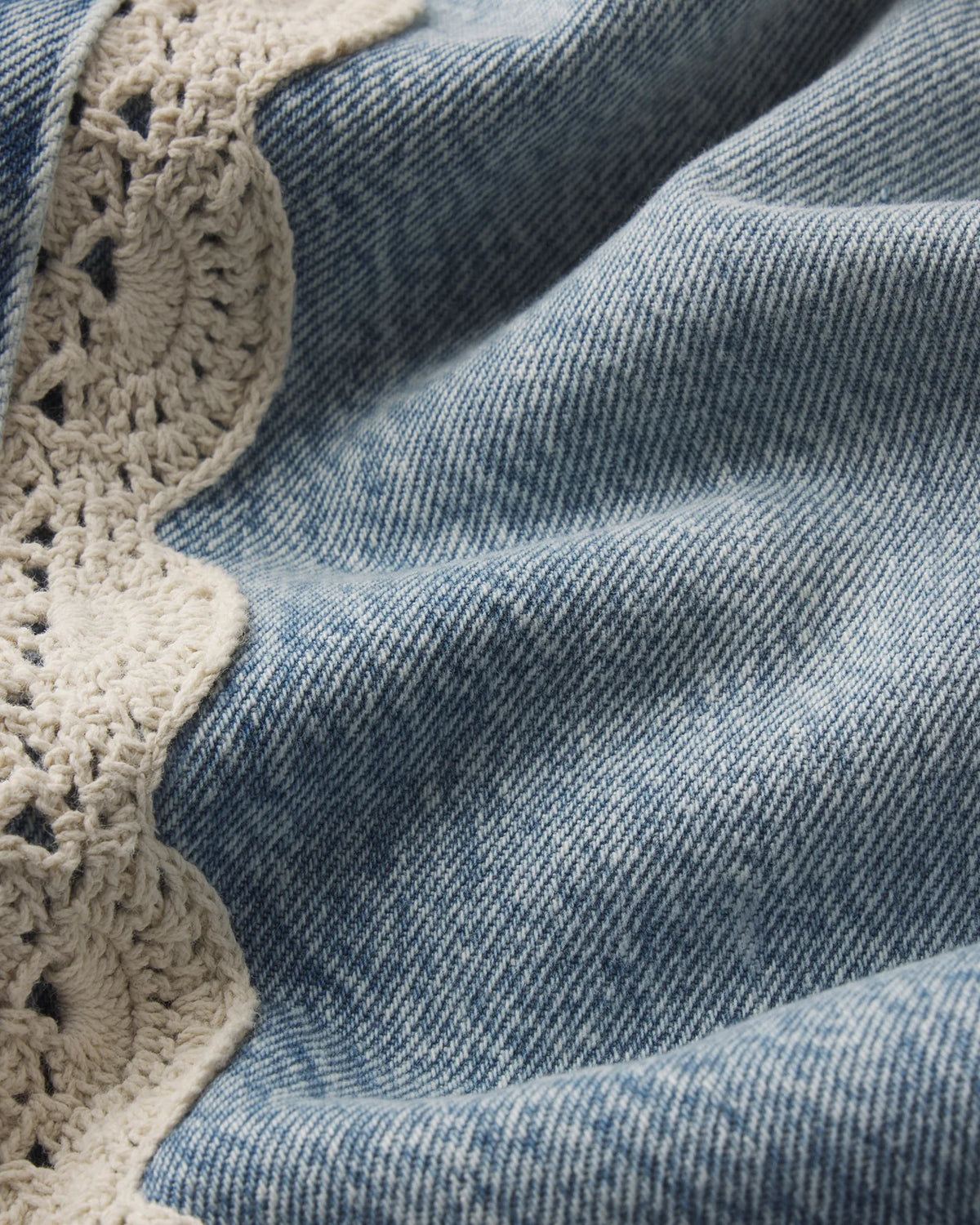 cropped light wash denim pant with a cream crochet detail on the sides