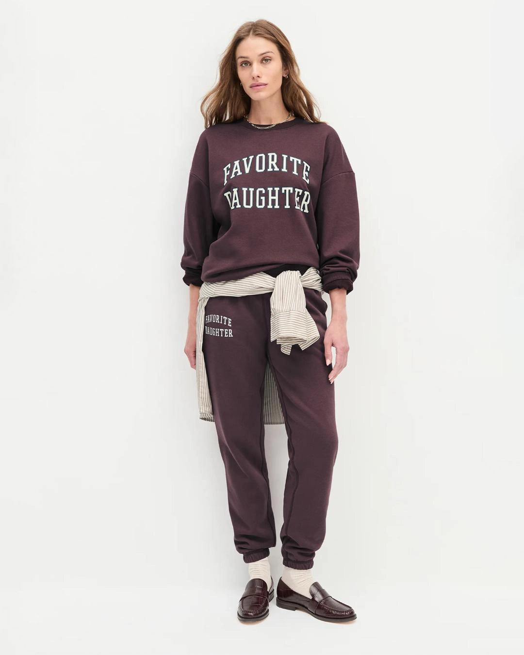Woman wearing a maroon 'FAVORITE DAUGHTER' sweatshirt and matching sweatpants