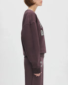 Woman wearing a maroon 'FAVORITE DAUGHTER' sweatshirt and matching sweatpants