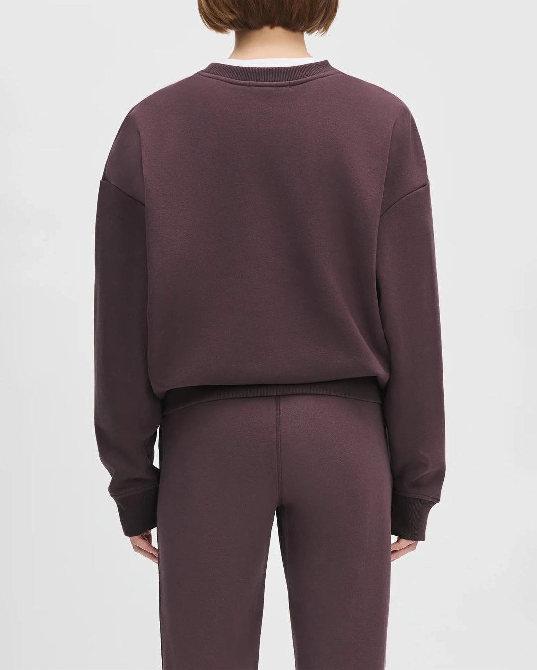 Woman wearing a maroon 'FAVORITE DAUGHTER' sweatshirt and matching sweatpants