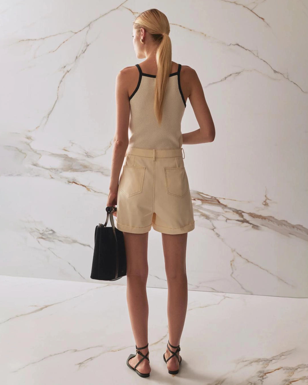 Person wearing beige high waisted denim shorts